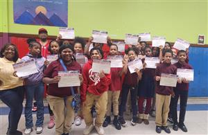middle school students holding certificates